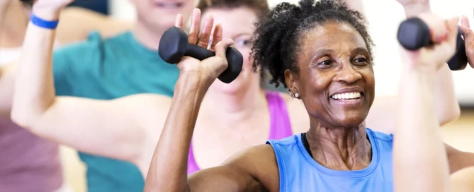 Older adults smiling and participating in a group for fitness classes for seniors at The Village in Tacoma, WA.