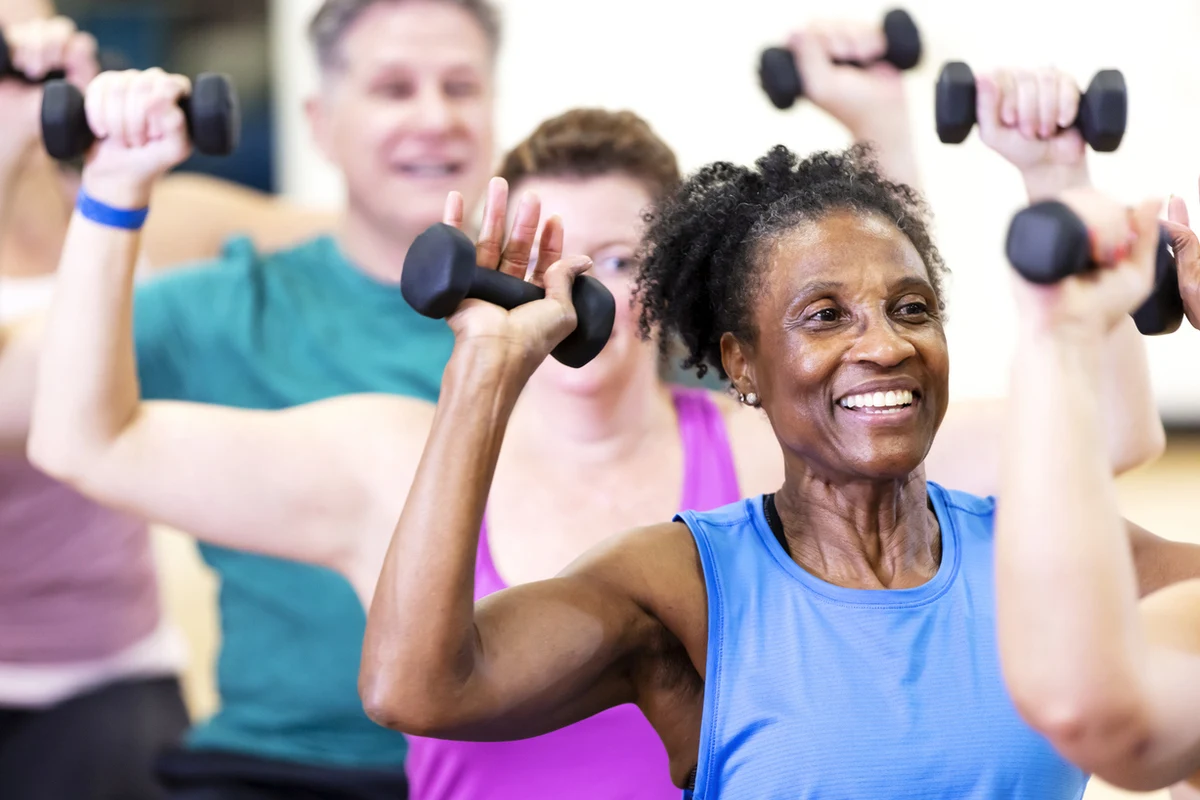 Older adults smiling and participating in a group for fitness classes for seniors at The Village in Tacoma, WA.