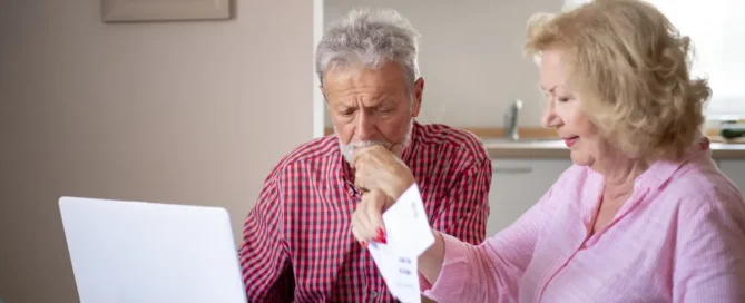 Serious older couple reviewing finances at home and asking when is assisted living needed for their future