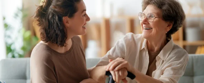 Signs your parent needs assisted living: daughter supports smiling senior mother with cane