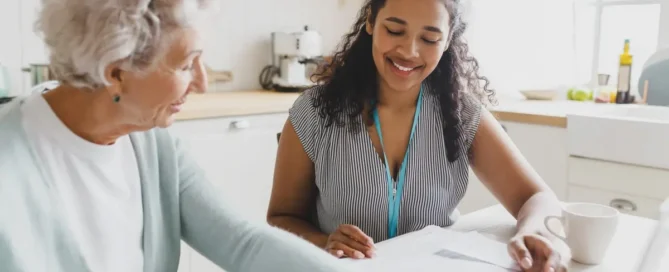 A caregiver gently assisting an elderly woman, representing the compassionate, hands-on support families find when they ask what to do when parents refuse assisted living at The Village assisted living in Tacoma, WA